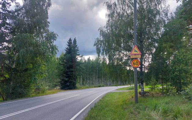 En vägskylt med en hjort på sidan av vägen