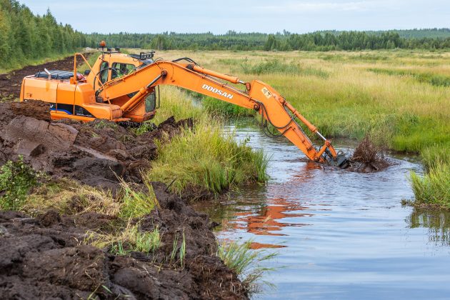 Grävmaskin gräver ett våtmark.