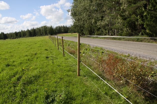 Sähköaita hiekkatien reunassa.